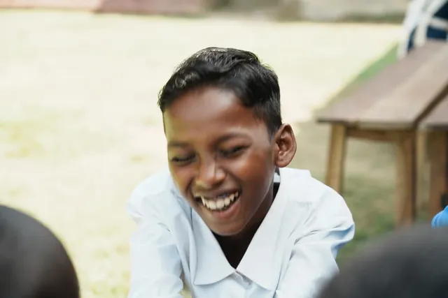 A boy laughing during an outdoor group activity